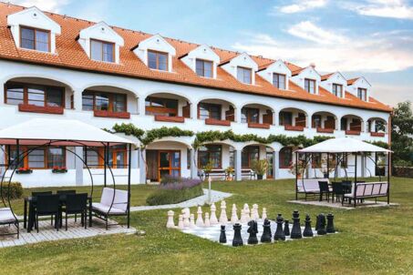 Aussenansicht Hotel Mörbischerhof Garten mit Schachbrett und überdachten Sitzmöglichkeiten