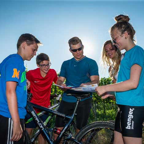 Familie mit Rädern berät über Wegstrecke der Fahrradtour